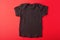 Layout black children`s t-shirt on a red background.Mockup .Flat lay