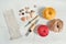 Layout of cotton yarn balls, punch needles, wooden buttons and sample of linen fabric on white wooden floor. Instruments and