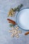 The layout of a plate with cutlery, scattered cinnamon, a sprig of Christmas trees and snowflakes.