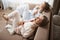 Lazy-bones doing nothing and enjoying leisure together. Upper-angle shot of cute women sitting in sofa in nightwear