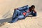 Lazy businessman laying in sand