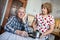 Lazy Caucasian man listens indifferently his wife, sitting with a TV remote in the kitchen