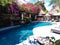 Lazy chairs by the swimming pool under bright sun