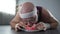 Lazy chubby man lying on the floor and eating donut after workout, addiction