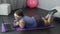 Lazy girl chatting in social media, lying on gym mat instead of sports workout