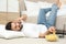 Lazy man with laptop, smartphone and bowl of chips lying on floor at home