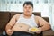 Lazy overweight male sitting with fast food