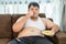 Lazy overweight male sitting with fast food