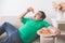 Lazy overweight man eating pizza while laying on a couch