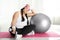Lazy overweight woman with fit ball and dumbbell