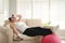 Lazy overweight woman with sport equipment on sofa