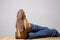 Lazy person concept: man`s legs wearing  blue jeans  of desert boots rest on a wooden table with copy space for your text