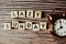Lazy Sunday alphabet letter with alarm clock on wooden background