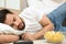 Lazy young man with bowl of chips and TV remote sleeping on floor at home