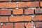 Ld wall from red brick. Red clay brick. Brick wall. The old crumbling brick wall. Bricks and stones in the old wall.