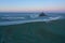 Le Mont Saint Michel castle surrounded by a winding stream on the sunset