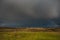 Leaden sky with rainbow over Val d`Orcia in Tuscany