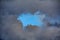 Leaden storm clouds with blue sky in center