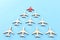 Leadership concept with airplanes on blue wooden background. One red leader flays ahead others.