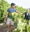 Leading her through the vines. A happy mature couple walking through a vineyard together.