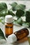 A leaf of ivy and syrup in a bottle on a light concrete table. Production of cough medicine with ivy extract. pharmaceutical indus