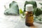 A leaf of ivy and syrup in a bottle on a light concrete table. Production of cough medicine with ivy extract. pharmaceutical indus