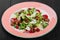 Leaf vegetable salad with roasted meat, baby spinach, melon, blue cheese, grated almonds and raspberry sauce on plate on dark wood