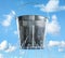 Leaky bucket with water against sky