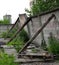 Leaning concrete fence with wooden supports