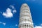 Leaning Tower Torre di Pisa on Piazza del Miracoli square, blue sky with white clouds background