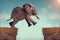 Leap of faith concept elephant jumping across a crevasse