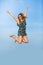 Leap of happiness. Joyful and smiling young woman jumps up with arms raised