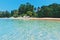 ï¿½lear blue sea and beach with palm trees. View from the sea to the Thailand beach, large stones on the shore and clean sand