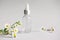 Ð¡lear glass serum cosmetic bottle with pipette and camomile herb laying near it