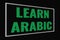 Learn Arabic green word on dark screen