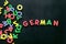 Learn German. Concept with letters on black background top-down copy space