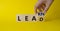 Learn and Lead symbol. Businessman hand Turnes cube and changes word Learn and Lead. Beautiful yellow background. Business and