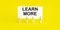 LEARN MORE , written on white sticky note on yellow background