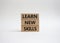 Learn new skills symbol. Concept words Learn new skills on wooden blocks. Beautiful white background. Business and Learn new