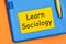 Learn Sociology the word is written in black letters on the yellow paper for notes