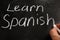 Learn Spanish handwritten sign on a blackboard