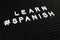 Learn Spanish language, modern looking sign on black background