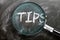 Learn, study and inspect tips - pictured as a magnifying glass enlarging word tips, symbolizes researching, exploring and