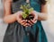 Learn to nurture the growth of nature. an unrecognizable young girl holding a plant growing out of soil while standing
