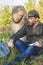 Learned historian sits before stone sculpture on mound