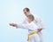 The learner with a yellow belt karate coach corrects