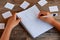 Learning English language. A small kid is writing subject pronouns. A notebook, a pen, cards with words on a wooden table