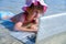 Learning always and everywhere. Humorous portrait of little cute girl learning remotely with laptop outdoors in tropical sea