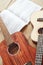 Learning how to play guitar. Vertical close up photo of acoustic and ukulele guitars lying on the wooden floor with