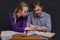 The learning process: students in a lesson at a table, a girl tells a young man